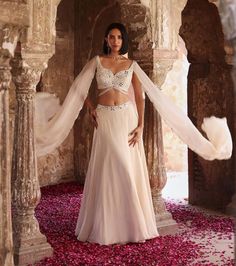 Indulge in sophistication with this embellished choli featuring attached flared sleeves, perfectly paired with a circular skirt adorned with an embellished belt and can-can detailing. This ensemble epitomizes elegance, offering a seamless blend of traditional charm and contemporary flair. Make a statement at any event or celebration with this exquisite outfit that exudes grace and style.