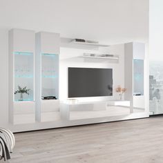 a living room with white furniture and a large flat screen tv mounted on the wall