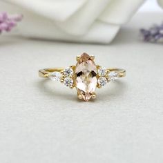 a ring with an orange and white stone surrounded by small diamonds on top of it