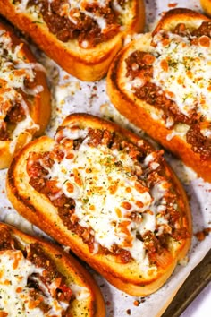 several pieces of bread with cheese and sauce on them