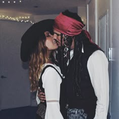 a couple dressed up as pirates kissing each other