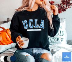 "UCLA Sweatshirt by varsitymerch * 50% Cotton; 50% Polyester * Medium - Heavy fabric * Soft fleecy lining * Air-jet spun yarn with a soft feel and reduced pilling * Ribbed knitted elastic collar * Unisex sizing - runs true to size All sweatshirts are made printed to order. Please expect slight color variances between the mock-up images on screen and the final printed design. *SIZES ARE UNISEX* - We'd suggest your usual size for a regular fit, or sizing up for a more relaxed fit. - Please see the size chart on the product images. -----Care Instructions----- Machine wash: warm (max 40C or 105F); Non-chlorine: bleach as needed; Tumble dry: medium heat; Do not iron; Do not dry clean. -----Shipping----- We offer free shipping to most countries! Below is an estimated shipping time: * Processing Ucla Sweatshirt, Senior Night, College Style, Workout Sweatshirt, Tour T Shirts, Black Sweater, College Fashion, Casual Tee, Lacrosse