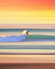 a person riding a surfboard on a wave in the ocean at sunset or sunrise