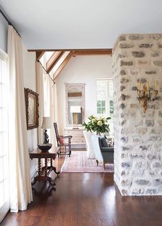 a living room filled with furniture next to a brick wall