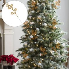 a decorated christmas tree with white and gold ornaments on it, next to a potted plant