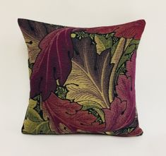 a red and green pillow sitting on top of a white wall