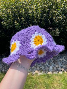 Violet crochet bucket hat with flowers all around the circumference as well as on the top! it has a wavy brim as well! Cute Crochet Brimmed Bucket Hat, Spring Crochet Yarn Bucket Hat, Spring Crochet Cloche Hat In One Size, Crochet Mini Bucket Hat For Spring, Spring Beach Crochet Hat With Flower Shape, Purple Crochet Summer Hat, Spring Crochet Mini Bucket Hat, Purple Crochet Hat For Beach Spring Season, Cute Hand Knitted Spring Hat