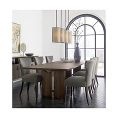 a dining room table with chairs and a vase on the table in front of an arched window