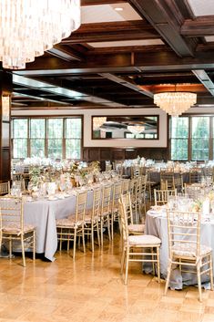 a room filled with lots of tables covered in white clothed tablecloths and chairs