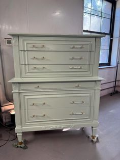 two white dressers with gold handles in a room