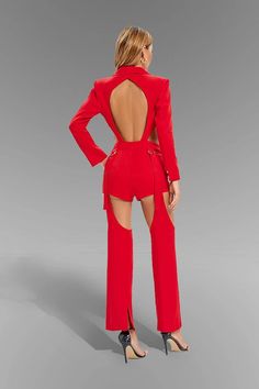 the back of a woman in a red jumpsuit with cut outs and high heels