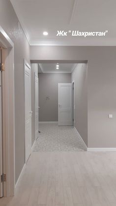 an empty hallway with white walls and wood floors