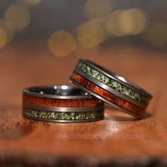 two wedding bands with wood and moss inlays