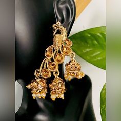 Step Out In Style With This Beautiful Gold Plated Earrings, Which Have Been Given A Drop Designer Dangler Perfectly Designed. It Will Add Bling To Your Look. This Earring Will Go Well With Any Of Your Ethnic Outfits. 2.5 In Long, 1 In Wide Gold Material Origin: India Will Not Tarnish Peacock Design Drop Earrings For Party, Peacock Design Dangle Earrings For Party, Elegant Peacock Design Earrings For Party, Party Jhumkas With Peacock Design, Party Peacock Design Dangle Earrings, Elegant Peacock Design Danglers For Parties, Elegant Peacock Design Jhumkas For Party, Gold Peacock Design Earrings For Formal Occasions, Gold Peacock Design Earrings For Formal Events