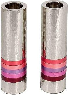 two silver vases with pink and purple ribbons on each one, both side by side