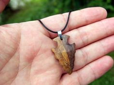 I hand-carved this one-of-a-kind arrowhead pendant from Spalted Walnut with very unique spalting lines. It's fully carved in the round on both sides so you can hang either way. I like the look of primitive arrowheads so I emulate that style in my carvings.  A hand rub finish is applied and then the pendant is buffed to a buttery smooth final finish that feels amazing to the touch.  You can choose from a variety of necklace/cording options including: 18" or 22" stainless steel chain A variety of Rustic Carved Jewelry As Gift, Brown Arrowhead Necklace For Gift, Rustic Arrowhead Necklace For Gift, Artisan Arrowhead Necklace For Gift, Unique Handmade Arrowhead Necklace, Carved Natural Wood Necklaces, Rustic Handmade Arrowhead Necklace, Carved Wood Necklace Pendants, Natural Necklace