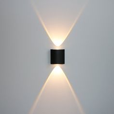 a wall light that is on the side of a white wall with two lights in it