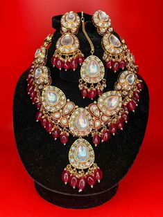 Necklace set with uncut polki, kundans and stones. It is paired with a matching pair of earrings and tikka. Style Tip - Wear this with almost anything Indian for a rich and royal look with this regal raani haar kundan necklace. Chandbali Ruby Jewelry Sets With Stone Work, Ruby Chandbali Jewelry Set With Stonework, Ruby Chandbali Jewelry Sets With Stone Work, Hand Set Kundan Necklace In Temple Jewelry Style, Temple Style Hand Set Kundan Necklace, Kundan Bridal Necklace With Stone Work Temple Jewelry Style, Bollywood Style Jeweled Bridal Necklace For Ceremonies, Kundan Chandbali Bridal Necklace With Stone Work, Ruby Kundan Necklace With Intricate Design For Diwali