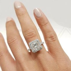 a woman's hand with a diamond ring on top of her finger and an engagement band