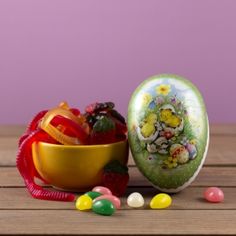 an egg decorated with flowers next to a bowl of candy