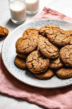 a white plate topped with cookies next to a glass of milk