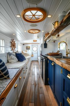 the interior of a boat with wood flooring and blue cabinetry on both sides