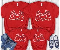 three red shirts with two hands making a heart and the other is holding up their hands