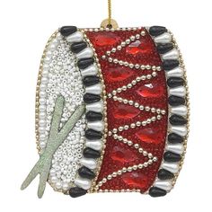 a red and white ornament hanging from a gold chain