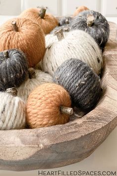 yarn balls and pumpkins in a wooden bowl