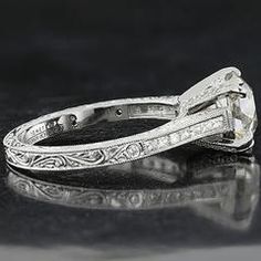 an antique style diamond ring on a black surface