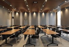 an empty classroom with desks and chairs in the center, along with a projector screen on the wall