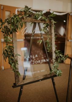 a sign with greenery on it in front of a window