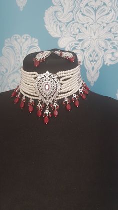 Beautiful pearl choker with matching earrings . Absolutely stunning pieces of jewelry.  Set includes ten strand choker necklace and matching earrings. Silver plated.  Ruby pink stones and beads have been added to finish the look. The set is traditional Hyderabadi design.  Picture do not do justice to the actual set.  Please make sure you have read our shop policies before making a purchase.  Thanks Formal Pearl Jewelry With Stone Work, Bollywood Style Pearl Jewelry For Formal Occasions, Traditional Pearl Choker Necklace For Parties, Elegant Chandbali Choker For Festivals, Elegant White Chandbali Choker, Traditional Pearl Choker For Wedding, Hand Set Pearl Bollywood Jewelry, Traditional Pearl Drop Choker Necklace, Elegant Jewelry Sets With Stone Work Choker