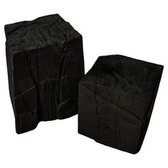 two pieces of black tarp sitting next to each other on a white background,