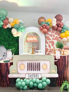 a safari themed birthday party with balloons, decorations and an old jeep in the background