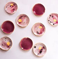 six small plates with different designs on them, one is purple and the other has yellow dots