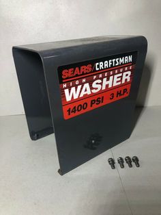 a washer box sitting on top of a white floor next to screws and nuts