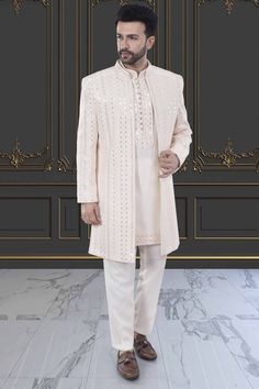 This Mens Sherwani (M42-S133) is an open jacket style with exquisite sequin and thread embroidery. The intricate detailing adds a touch of elegance to this traditional attire. Perfect for weddings and special occasions, this sherwani is a must-have for anyone looking to make a statement. Eid Reception Suits With Resham Embroidery, Elegant Nehru Jacket With Mirror Work For Festive Occasions, Elegant Festive Outerwear With Dabka Work, Elegant Nehru Jacket With Mirror Work For Transitional Season, Elegant Sherwani With Mirror Work And Long Sleeves, Elegant Sherwani With Mirror Work, Elegant Wedding Sherwani With Mirror Work, Elegant Festive Outerwear With Mirror Work, Formal Traditional Wear With Mirror Work And Traditional Drape