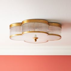 a ceiling light that is hanging from the ceiling in a room with pink walls and white trim