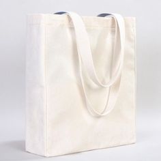 a white canvas bag on a white background with a blue handle and two black handles