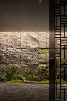 the interior of a building with stone walls and plants