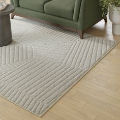 a living room with a green couch and white rug