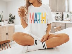 a woman is sitting on the kitchen counter drinking from a glass while holding a straw