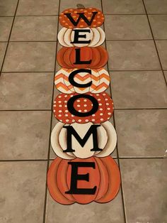 a welcome sign made out of pumpkins on the floor