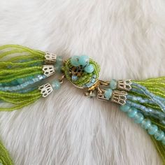 "This is a vintage 1970's statement necklace. The primary strands of the necklace are a light green seed bead. The beads are very delicate but still in good condition. The other strands of the necklace are light blue tone beads. The clasp is a silver tone metal with the same green and blue beading covering the top of the clasp. Some of the beads are missing from the top of the clasp, but it is something that is not very noticeable given the placement. The necklace is in good condition. Measureme Multi-strand Green Large Beads, Green Multi-strand Beaded Necklaces With Large Beads, Green Multi-strand Beaded Necklace With Large Beads, Vintage Green Faceted Beads, Vintage Multi-strand Colorful Beaded Necklaces, Vintage Multi-strand Beaded Necklace With Colorful Beads, Vintage Multi-strand Beaded Necklaces With Colorful Beads, Vintage Multi-strand Beaded Chain Necklaces, Vintage Green Beads For Jewelry Making