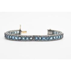 Pair of London blue topaz and diamond bangles mounted in sterling silver with a 14k gold tongue clasp and safety. Each bracelet contains princess cut blue topaz prong set down the center with round diamonds along the side edges.  The 2 bracelets have a combined carat weight of 5.28 carats in diamonds and 61.23 in London blue topaz.  Internal circumference is 7.12".  across inside 2 3/8" by 2 5/16" Timeless Blue Jewelry With Single Cut Diamonds, Diamond Bracelets With Gemstone Accents For Anniversary, Fine Jewelry Diamond Bracelet With Gemstone Accents, Diamond Bracelet With Gemstone Accents, Exquisite Blue Jewelry With Single Cut Diamonds, Fine Jewelry Blue Topaz Bracelets, Exquisite Blue Topaz Jewelry With Prong Setting, Luxury Blue Topaz Gemstone Bracelets, Luxury Blue Topaz Bracelets