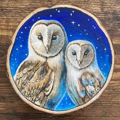 two owls sitting on top of a piece of wood with stars in the sky behind them