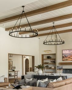 a living room filled with lots of furniture and a chandelier hanging from the ceiling