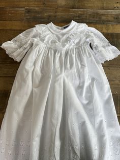 A beautiful vintage baby's Christening robe made by Sturgenegger, Switzerland.  100% Baumwolle, high quality cotton. It has a small collar, lace and appliqué puffed sleeves.  It has a cotton lining. Three buttons at the back.  Lace and appliqué front and hem.  Length 81cm Chest 25 cm  It is bright white and is in lovely condition. Long Sleeve Baptism Dress With Ruffles, Long Sleeve Baptism Dress With Ruffles For First Communion, Fitted Cotton Baptism Dress With Ruffles, Fitted Cotton Baptism Dress For Spring, Fitted Long Sleeve Baptism Dress For Spring, Fitted Broderie Anglaise Baptism Dress For Spring, Spring Baptism Dress With Lace Collar, Spring Baptism Dress In Broderie Anglaise Cotton, Spring Cotton Baptism Dress