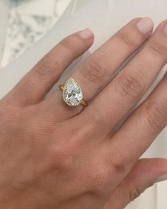 a woman's hand with a ring on it and a diamond in the middle